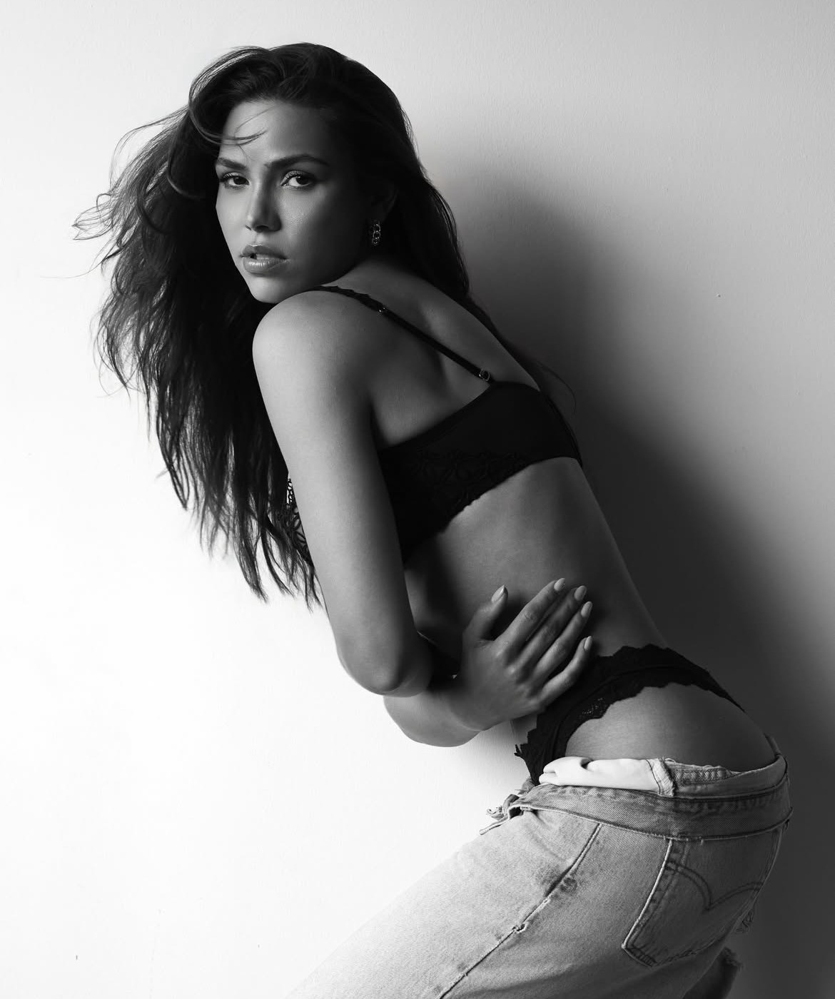 Black and white studio editorial against a white wall