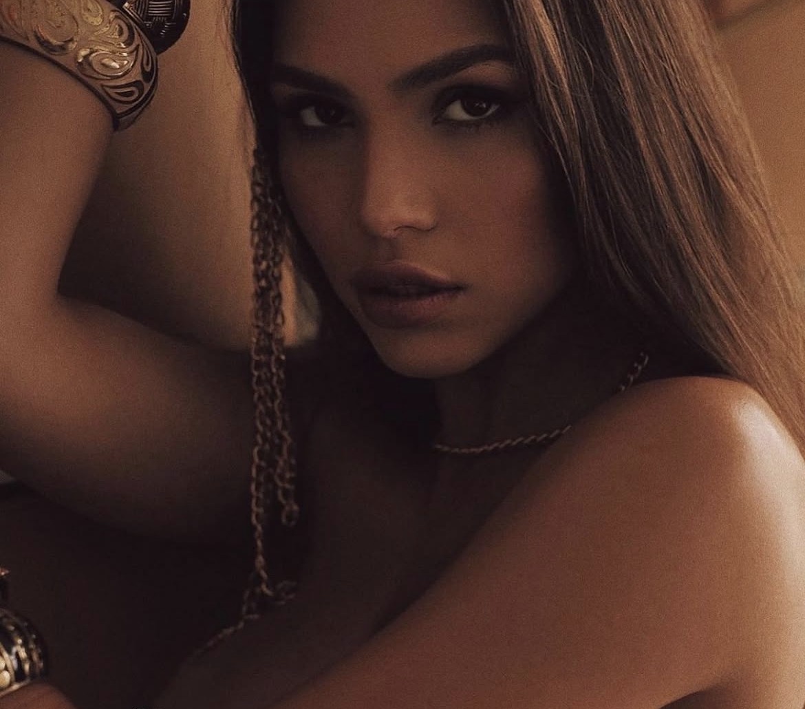 Warm sepia editorial with gold cuffs and chains